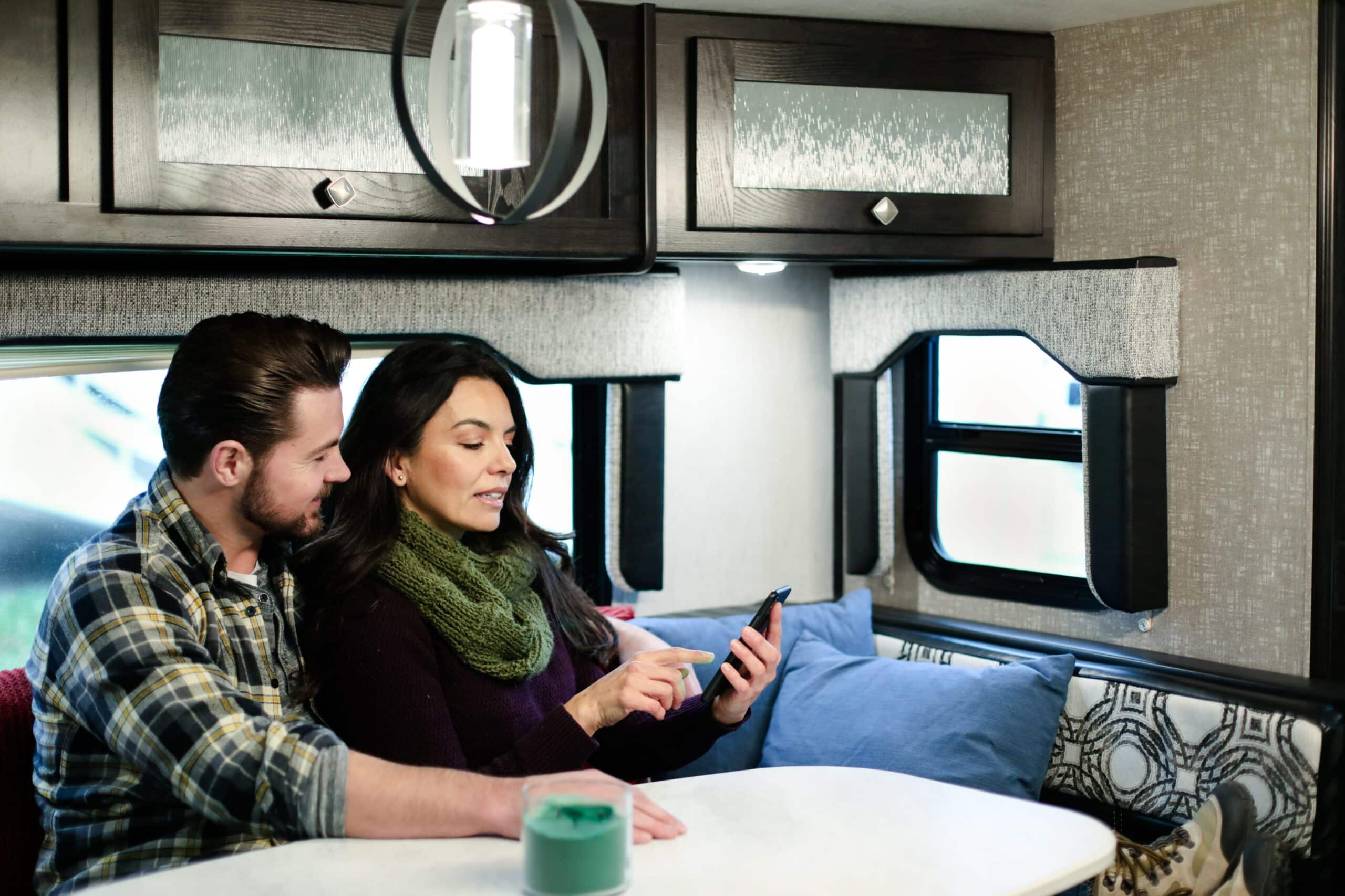 Couple using their phone inside their RV camper