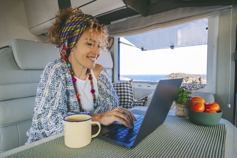 woman using her laptop while inside an RV